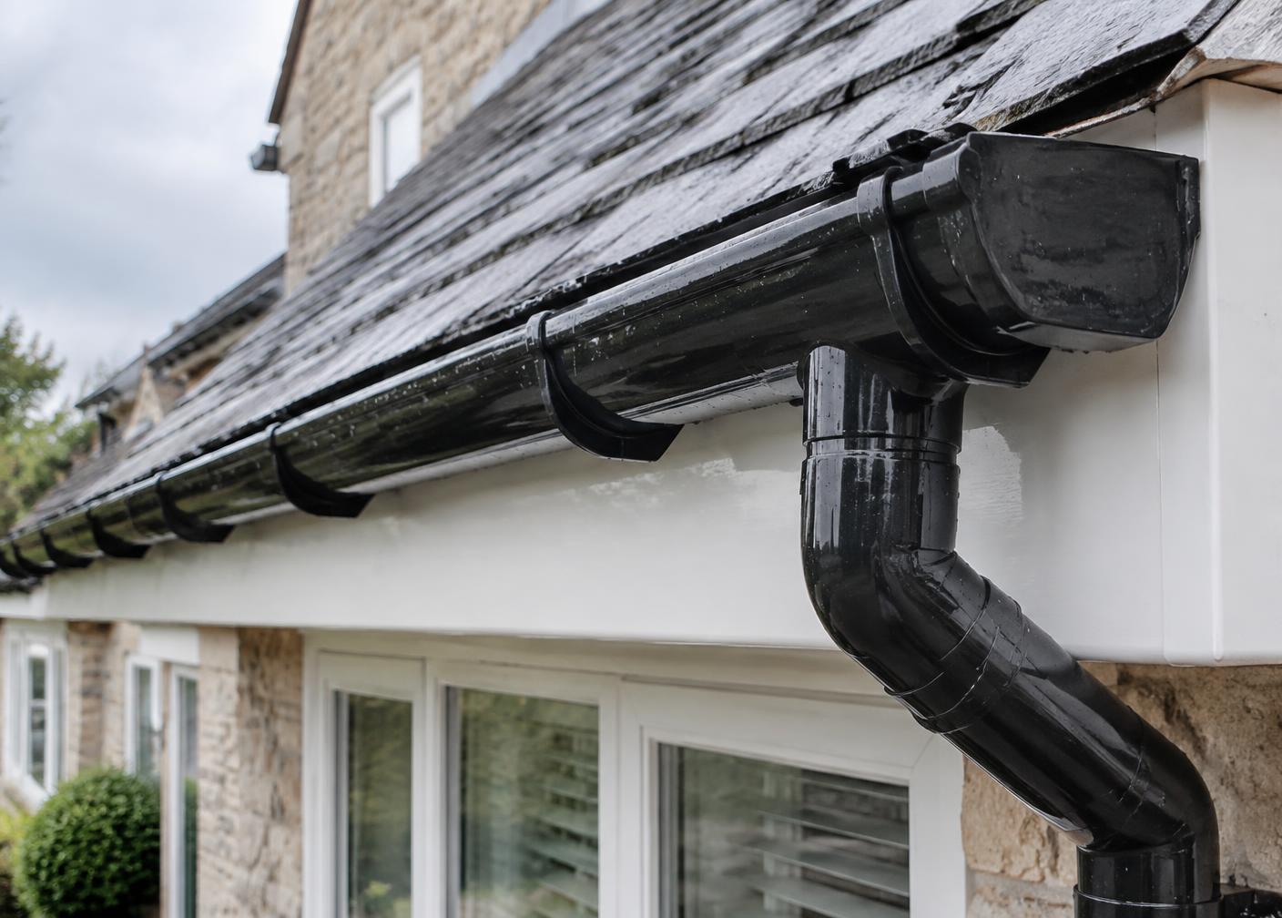 Clean black gutter and downpipe after gutter cleaning on a Surrey home